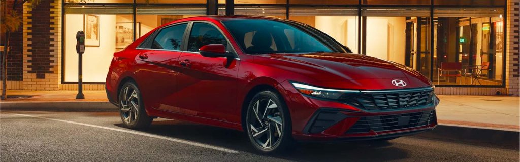 A vibrant red 2026 Hyundai Elantra, parked in a modern urban setting, emphasizing its elegant lines and modern automotive aesthetics.