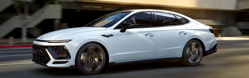 A 2026 Hyundai Sonata in motion on a road, showcasing its sleek design.