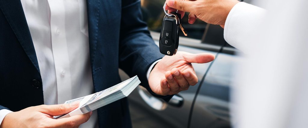 Close-up of a car trade-in transaction with a person handing over car keys while receiving payment, symbolizing the exchange process during a vehicle trade-in.