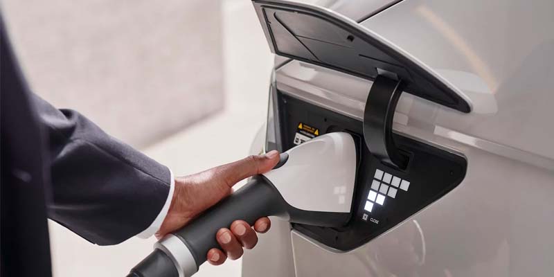 Close-up of man's hand connecting EV charger to Hyundai Ioniq