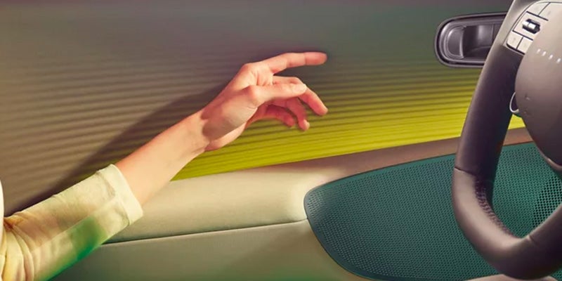 Hand reaching toward car door panel from passenger seat