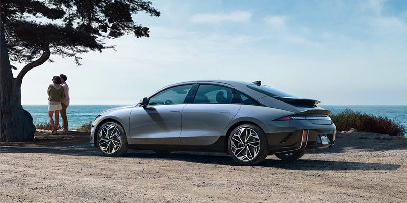 Hyundai IONIQ 6 by the sea with couple enjoying the view