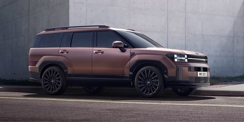 Side view of Hyundai Santa Fe parked beside a wall.