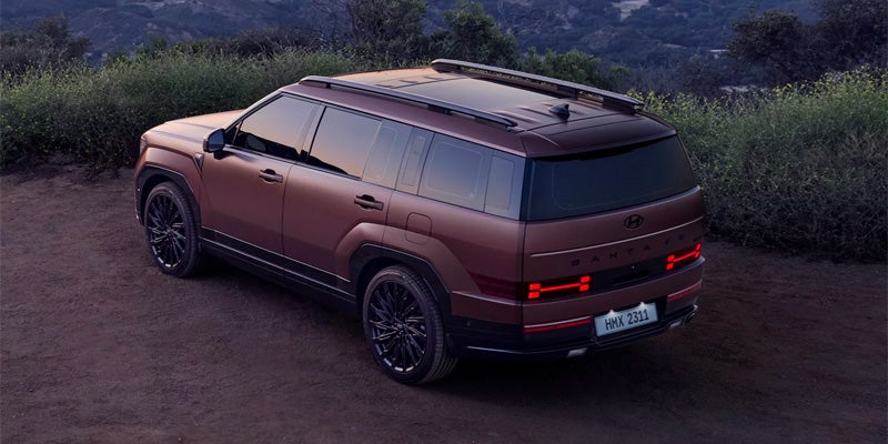 Hyundai Santa Fe parked on dusky terrain with mountains in the background