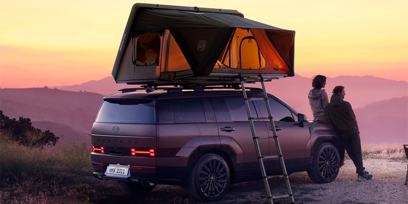 Hyundai Santa Fe with rooftop tent at sunset overlooking mountains