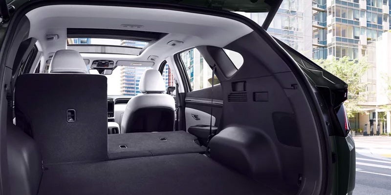 Rear interior view of Hyundai Tucson with folded seats, parked in urban setting